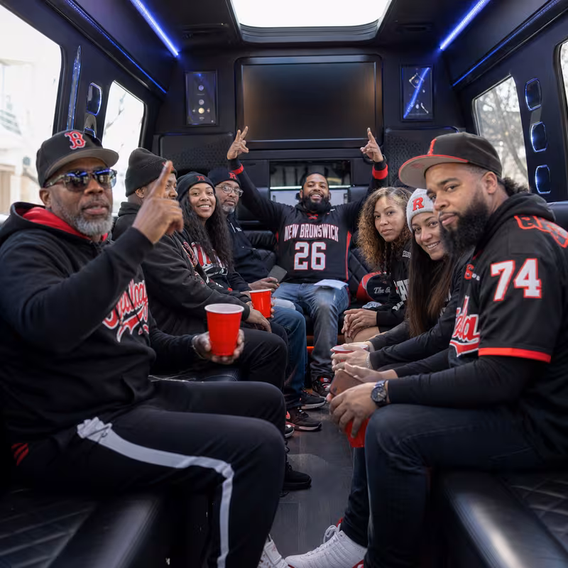 Group boarding a white charter bus for Sporting Event Transportation transportation in New Brunswick